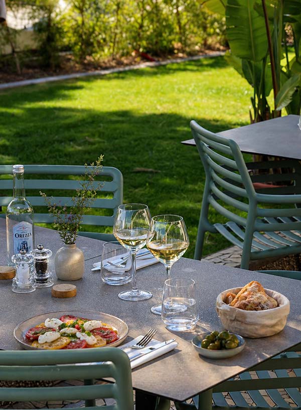 Terrasse du restaurant Le Kallisté à l’Ayguade à Hyères avec table dressée, plats et ambiance jardin proche de la plage