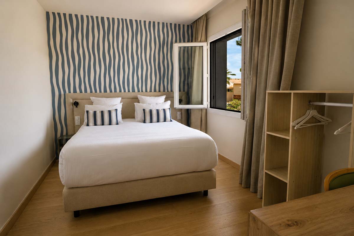 Chambre Double Classique — Hôtel Le Kallisté à Hyères L’Ayguade dans le Var Chambre double classique lumineuse de l’Hôtel Le Kallisté à Hyères L’Ayguade dans le Var avec lit double et décoration contemporaine