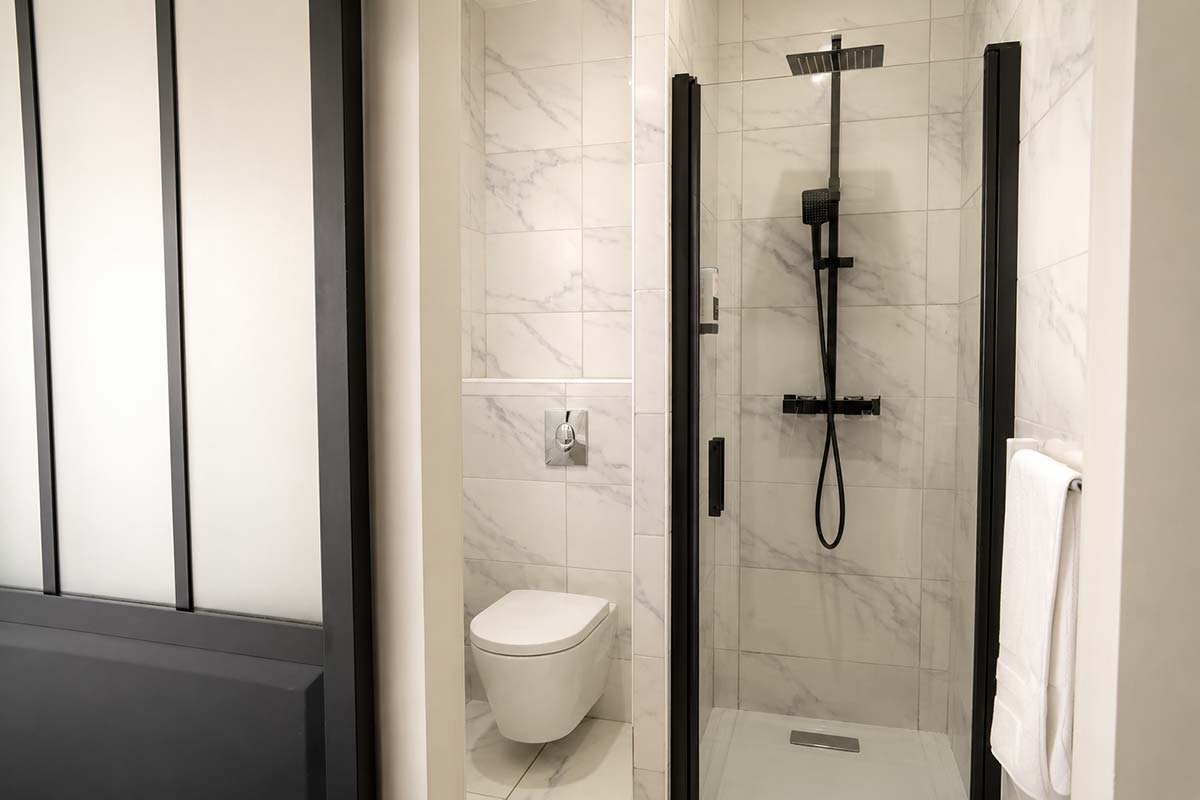 Salle de bain Chambre Double Classique — Hôtel Le Kallisté à Hyères L’Ayguade Salle de bain moderne avec douche à l’italienne dans une chambre double classique de l’Hôtel Le Kallisté à Hyères L’Ayguade