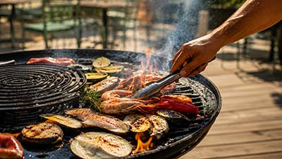 Cuisson au brasero au restaurant Le Kallisté à Hyères avec viandes et légumes grillés au feu de bois sur terrasse extérieure