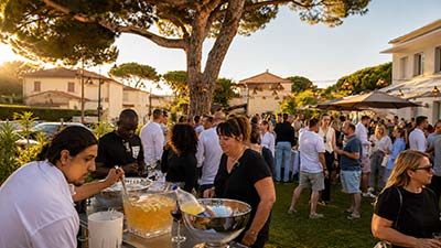 Cocktail en extérieur dans le jardin du restaurant Le Kallisté à Hyères avec convives et ambiance conviviale sous les pins méditerranéens